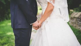 Midsection Of Couple Holding Hands At Wedding