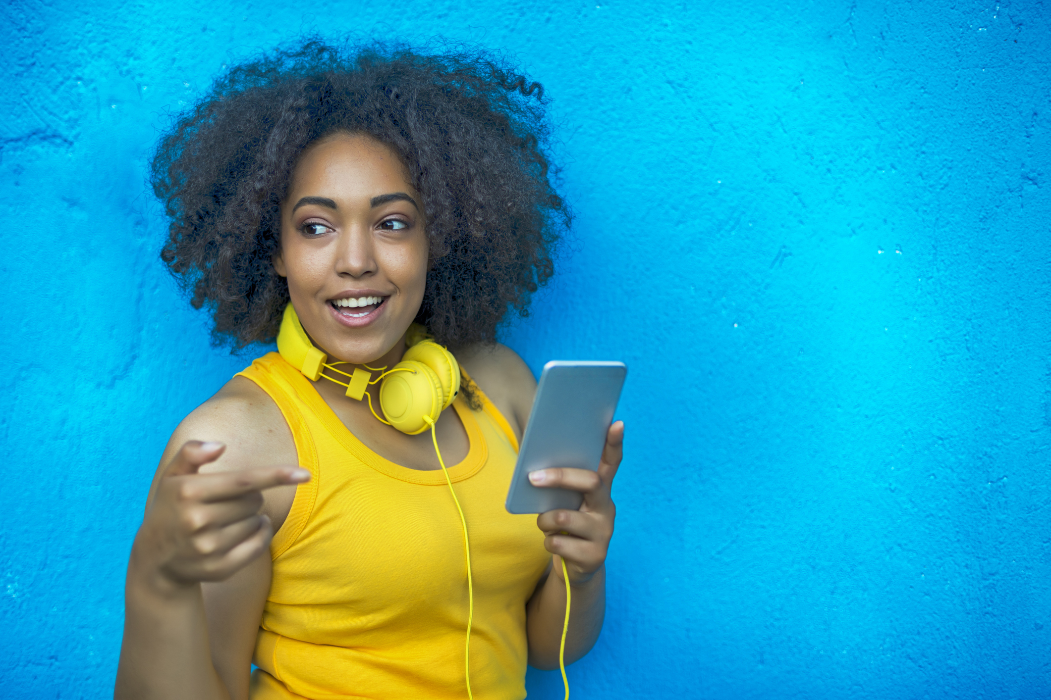 Smiling woman with yellow vest and headphones listening music