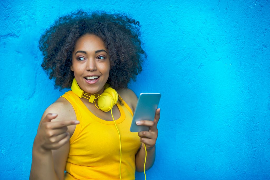 Smiling woman with yellow vest and headphones listening music