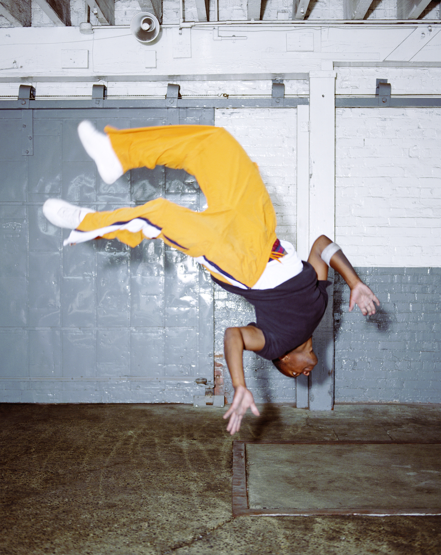 Young male breakdancer doing backflip (blurred motion)