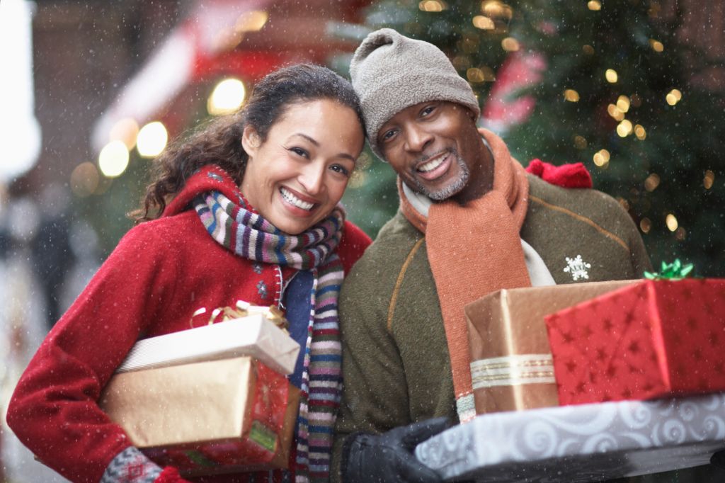 Couple with Christmas presents on street, portrait