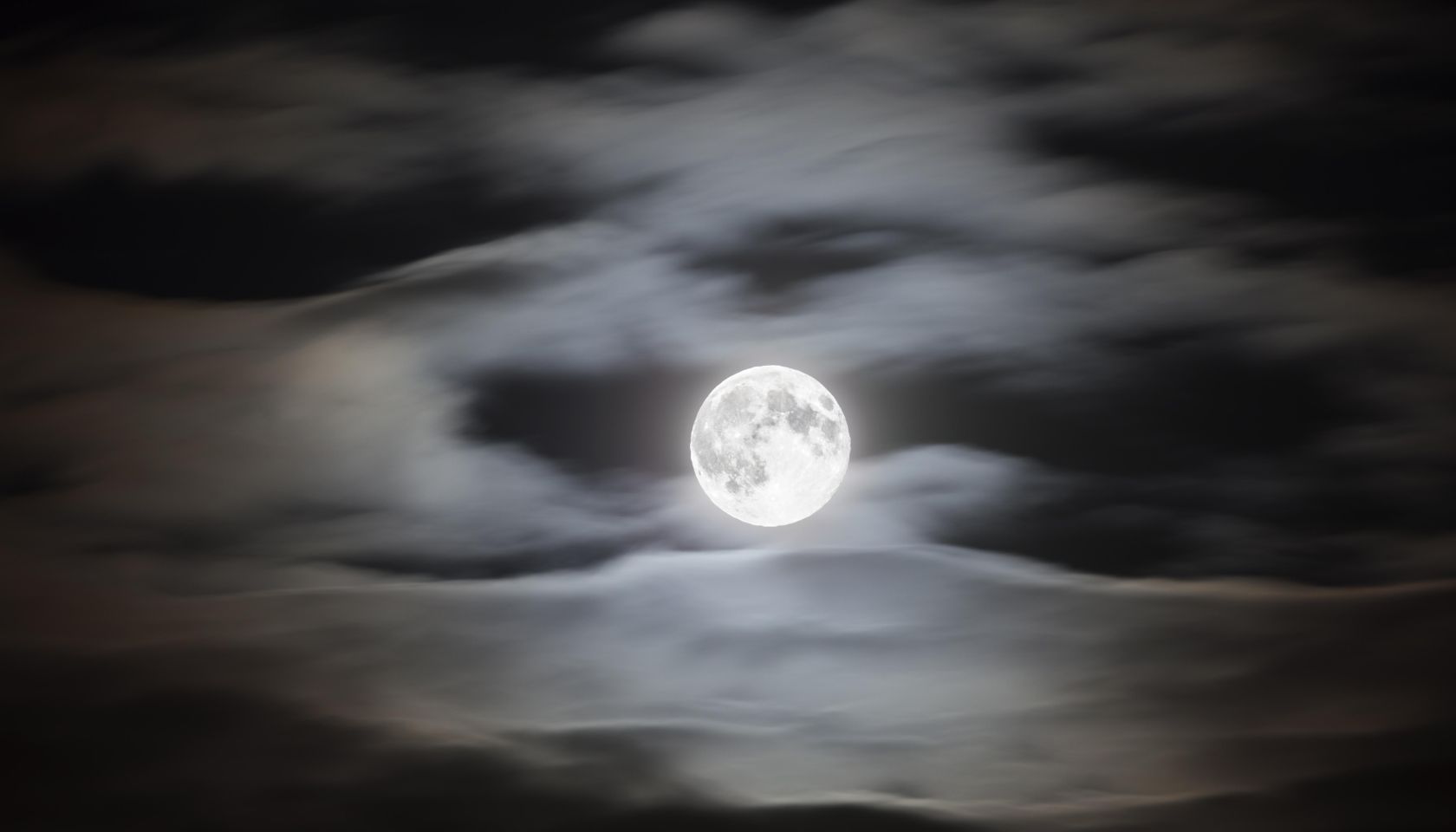 Full moon on a cloudy night sky