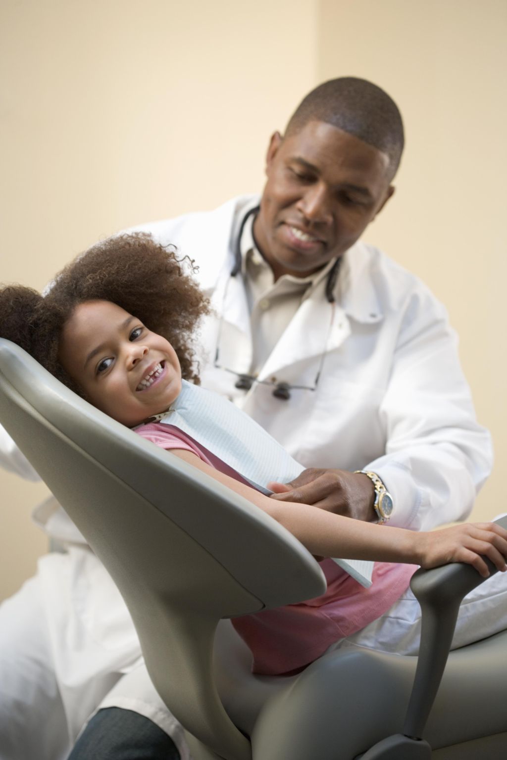 Girl (4-6) sitting in dental chair with dentist