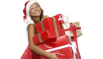 Smiling young woman with Christmas gifts. Isolated on white background with clipping path