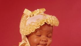 Black Baby Wearing Yellow Bonnet