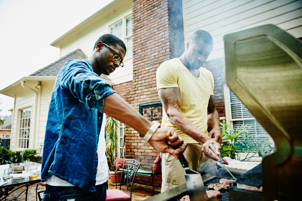 Friends barbecuing during backyard party