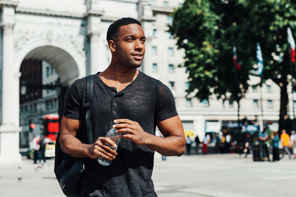 Afro-Caribbean guy in London with bottle of water