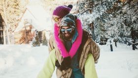 Man walking through deep snow with woman on his back