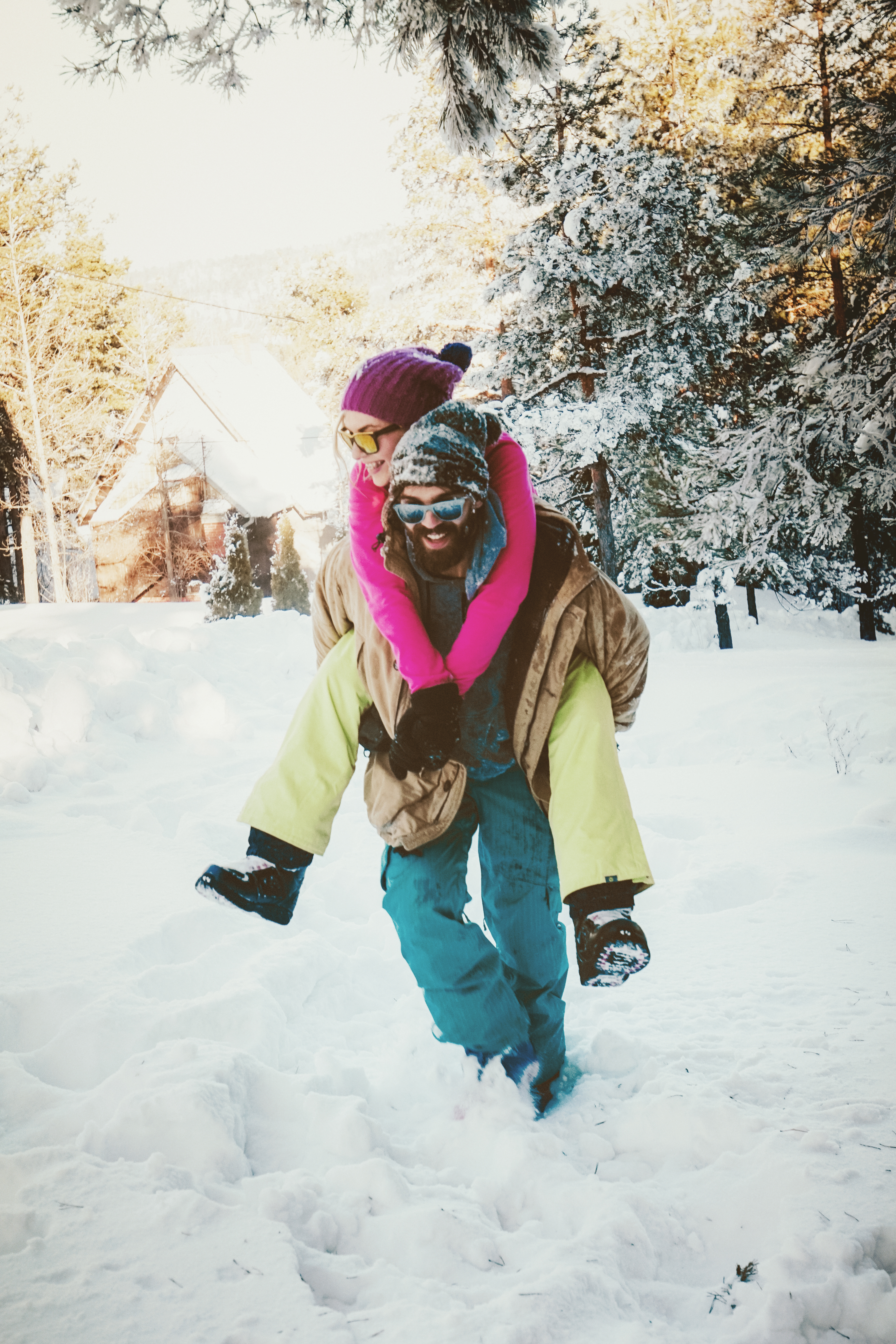 Man walking through deep snow with woman on his back