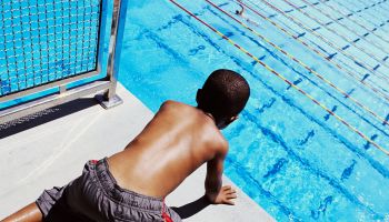 Boy (5-7) looking over diving platform, elevated view