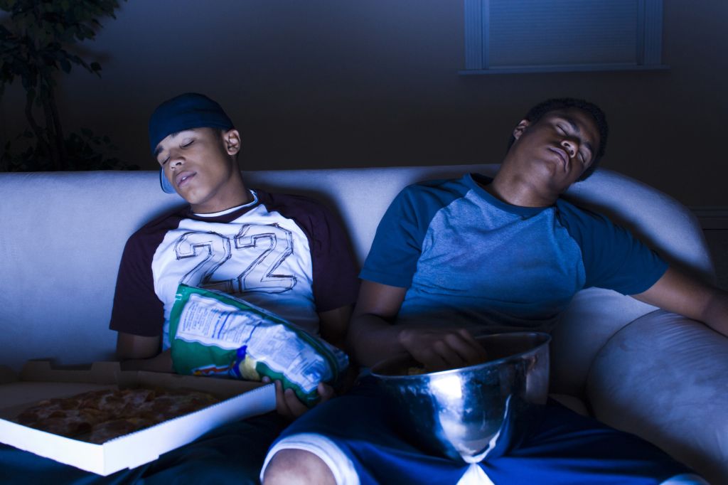 Young men asleep in front of the TV