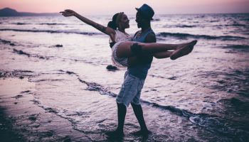 Young romantic couple having fun at the beach after sunset