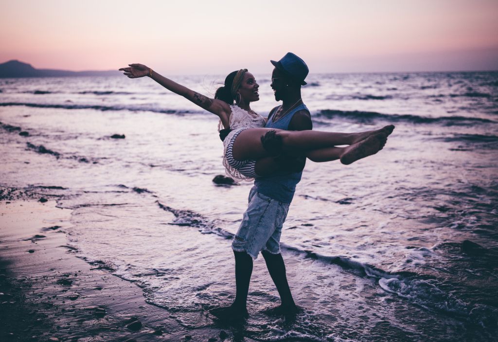 Young romantic couple having fun at the beach after sunset