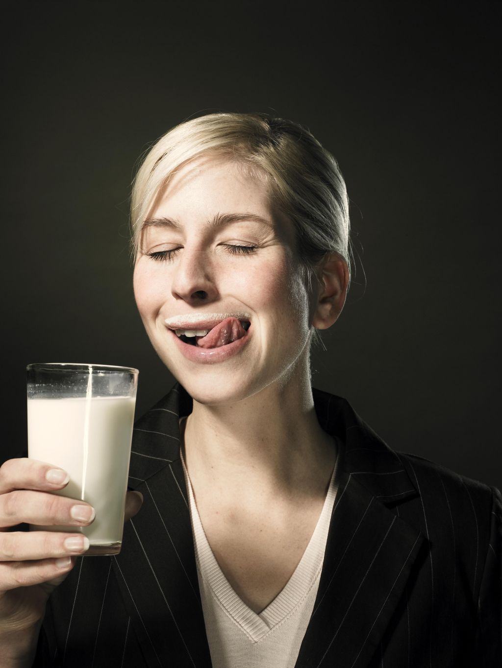 Young woman holding glass of milk, close-up