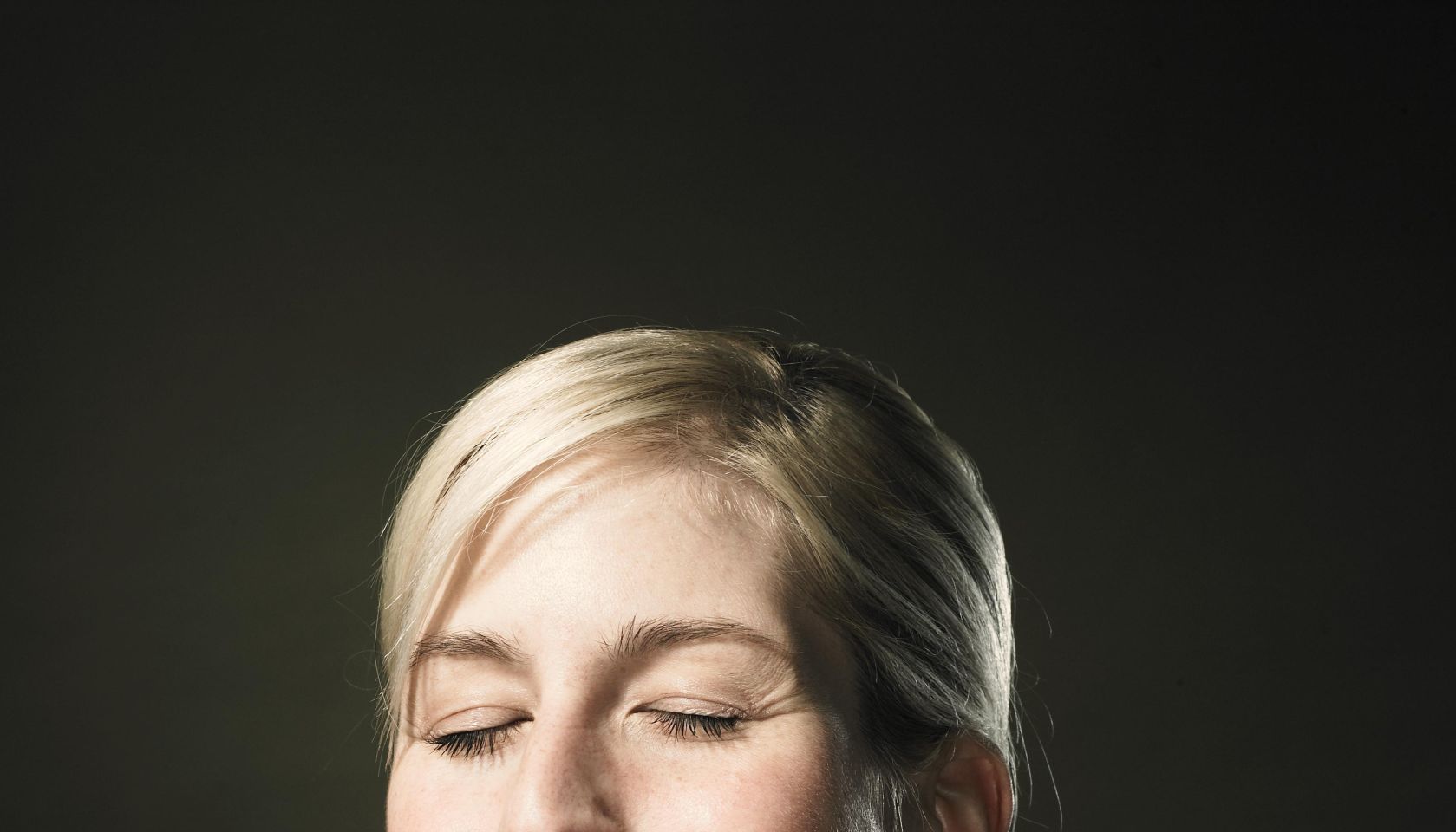 Young woman holding glass of milk, close-up