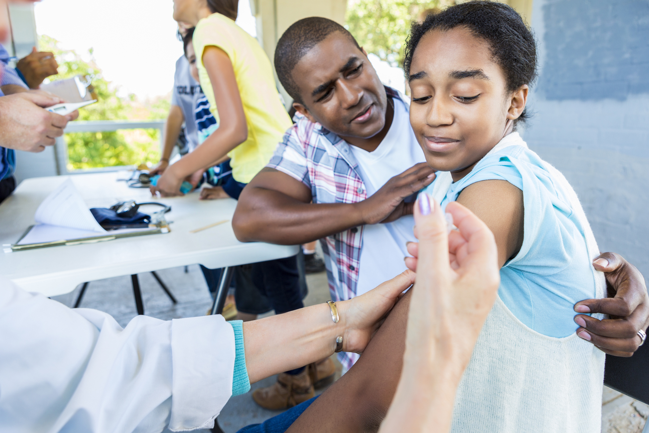 Girl receives flu shot at outdoor free clinic