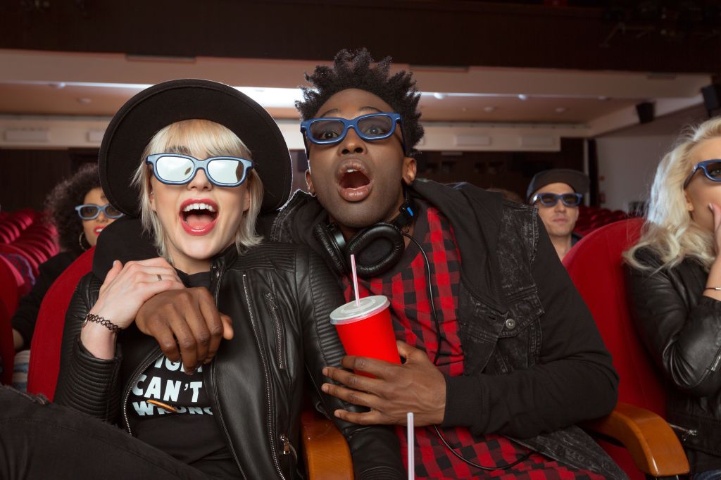 Multi ethnic young couple in 3D movie theater