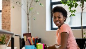 Happy black woman working online at a creative office