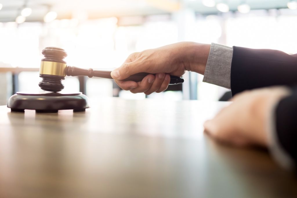 Cropped Hands Of Man Holding Gavel At Table