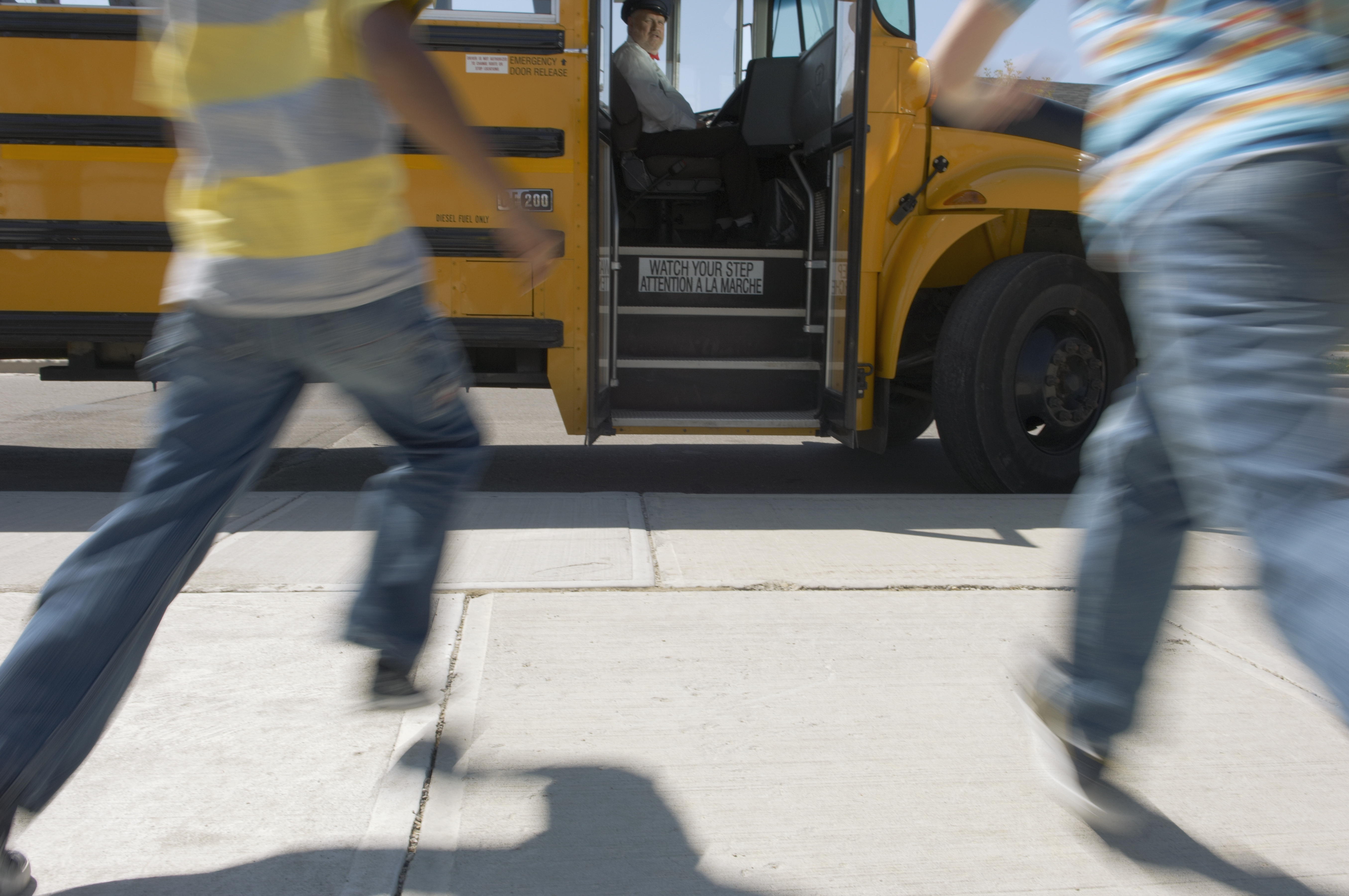 Schoolchildren running to schoolbus