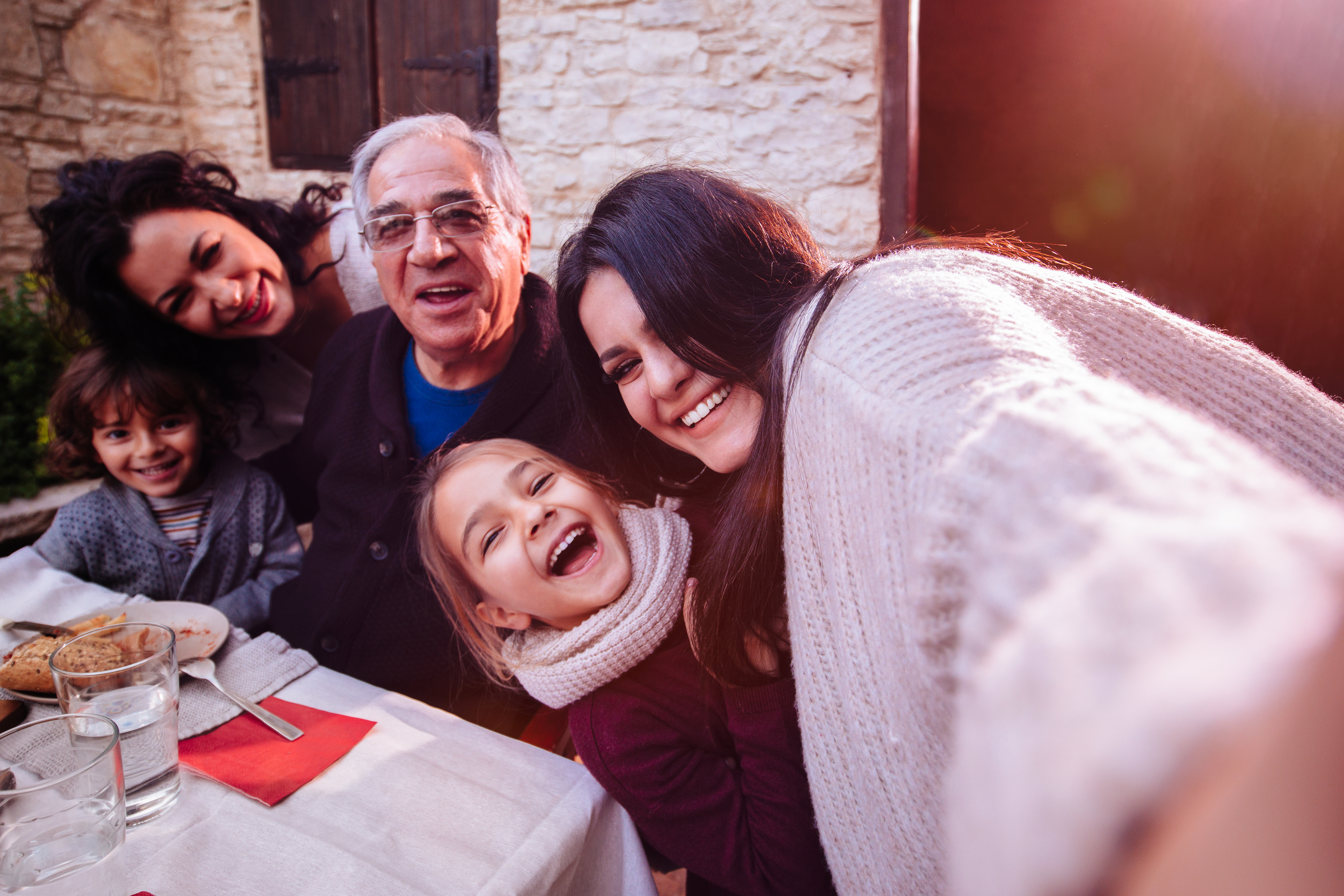 Three-generation family taking selfies at traditional family lunch