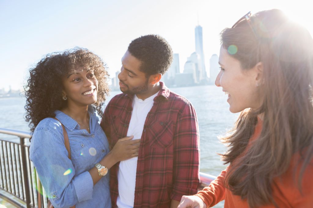 Young couple talk with female friend on vacation