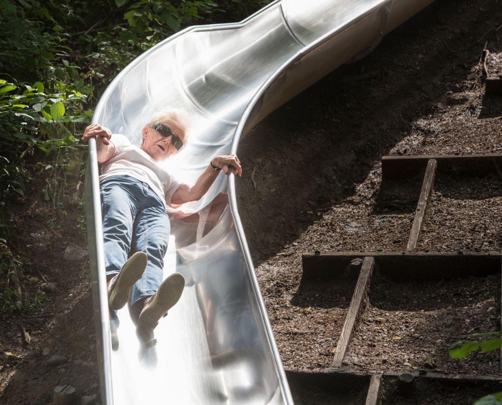 Woman sliding down playground slide