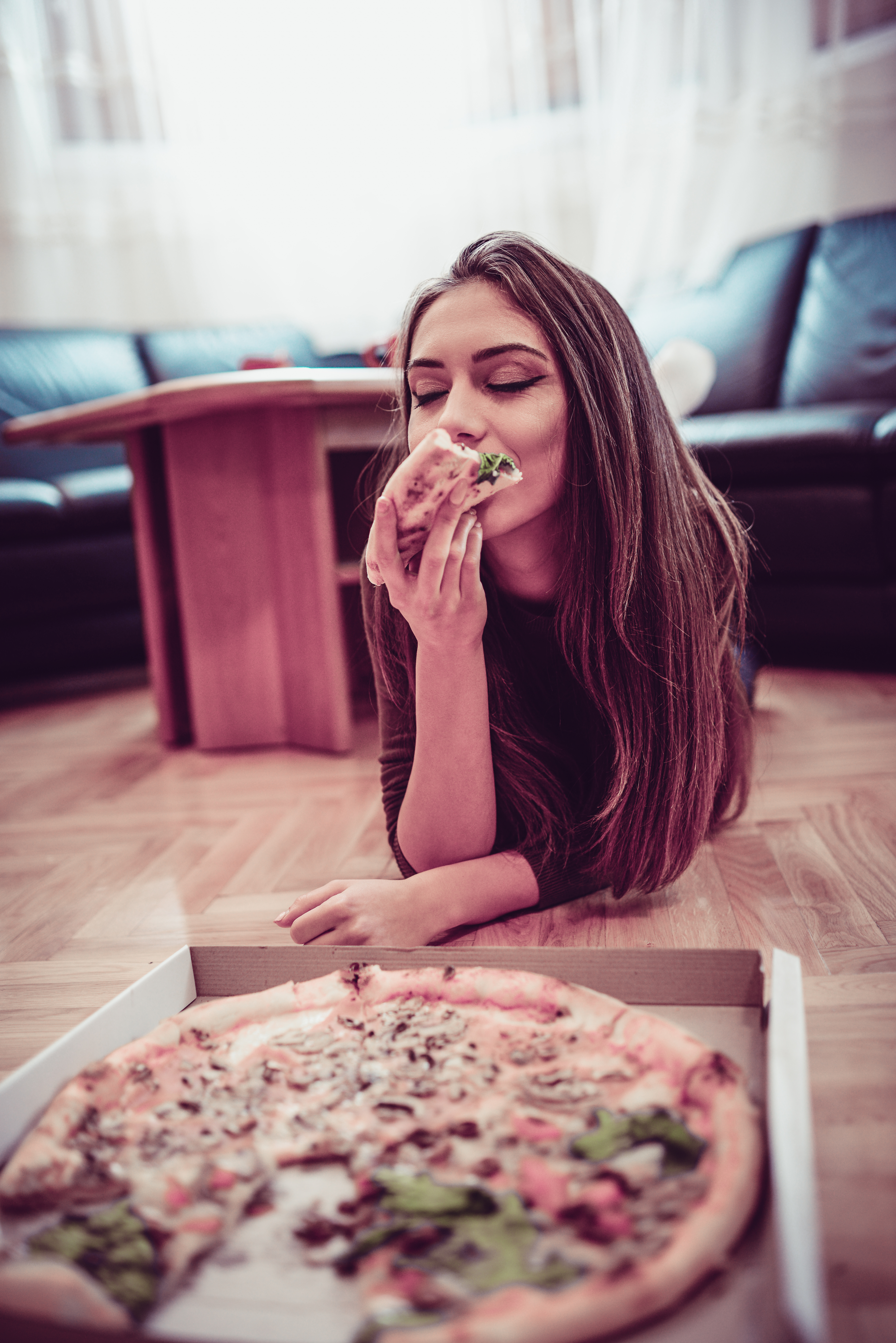 Young Cheerful Female Eat Pizza on the Floor at Home