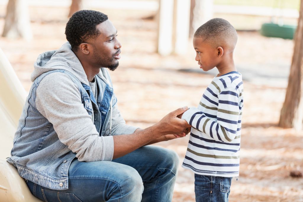 Father talking to little boy on playground