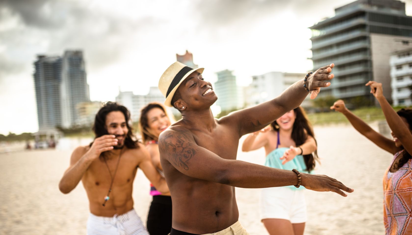 friends dancing on the beach for a party