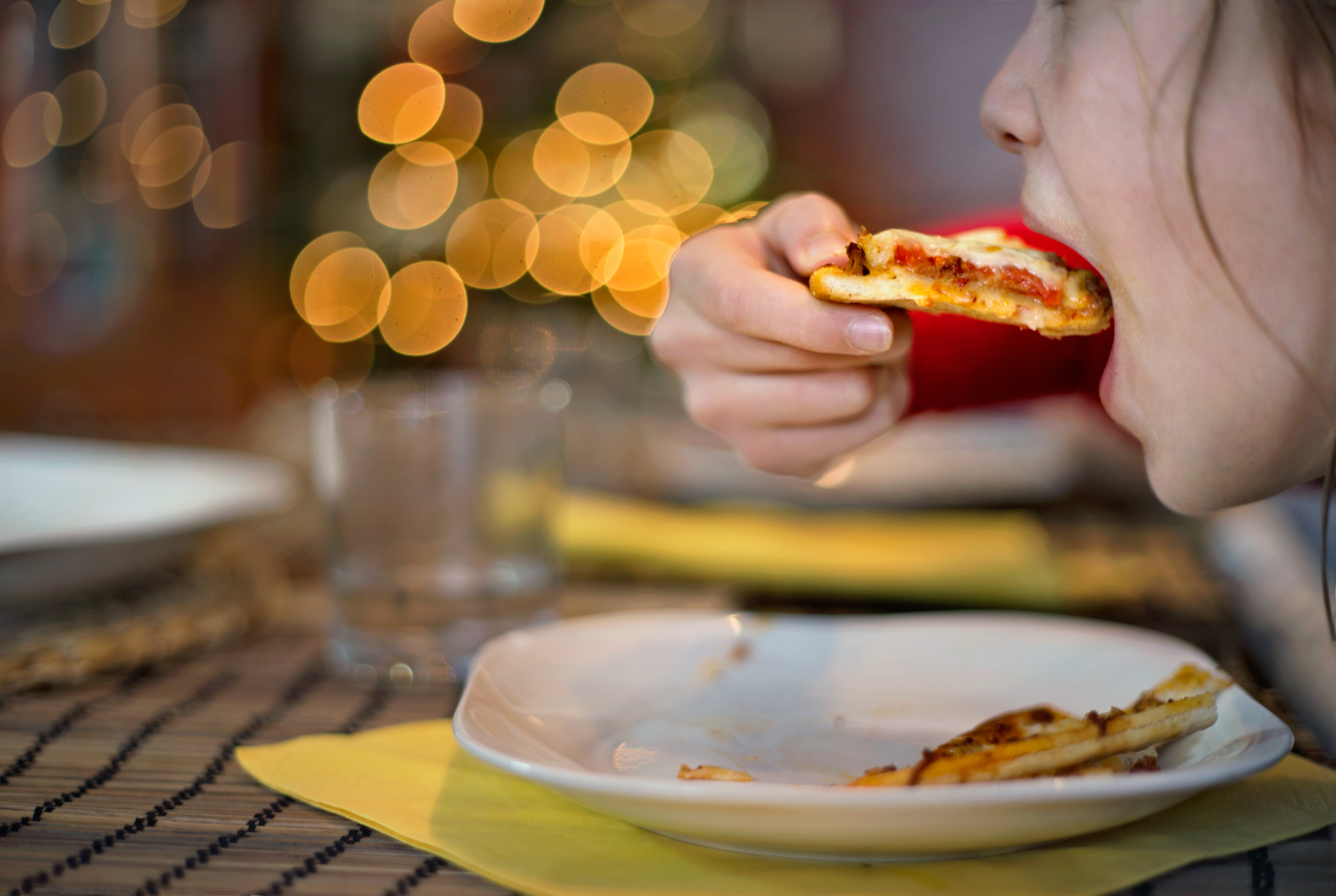 Lifestyle. Young girl eating pizza.