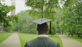 Male college student wearing cap and gown, rear view