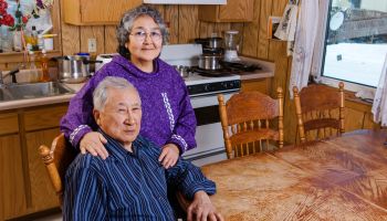 Elder Alaska native couple in their kitchen sitting at the kitchen table, Noatak, Arctic Alaska, USA, Winter
