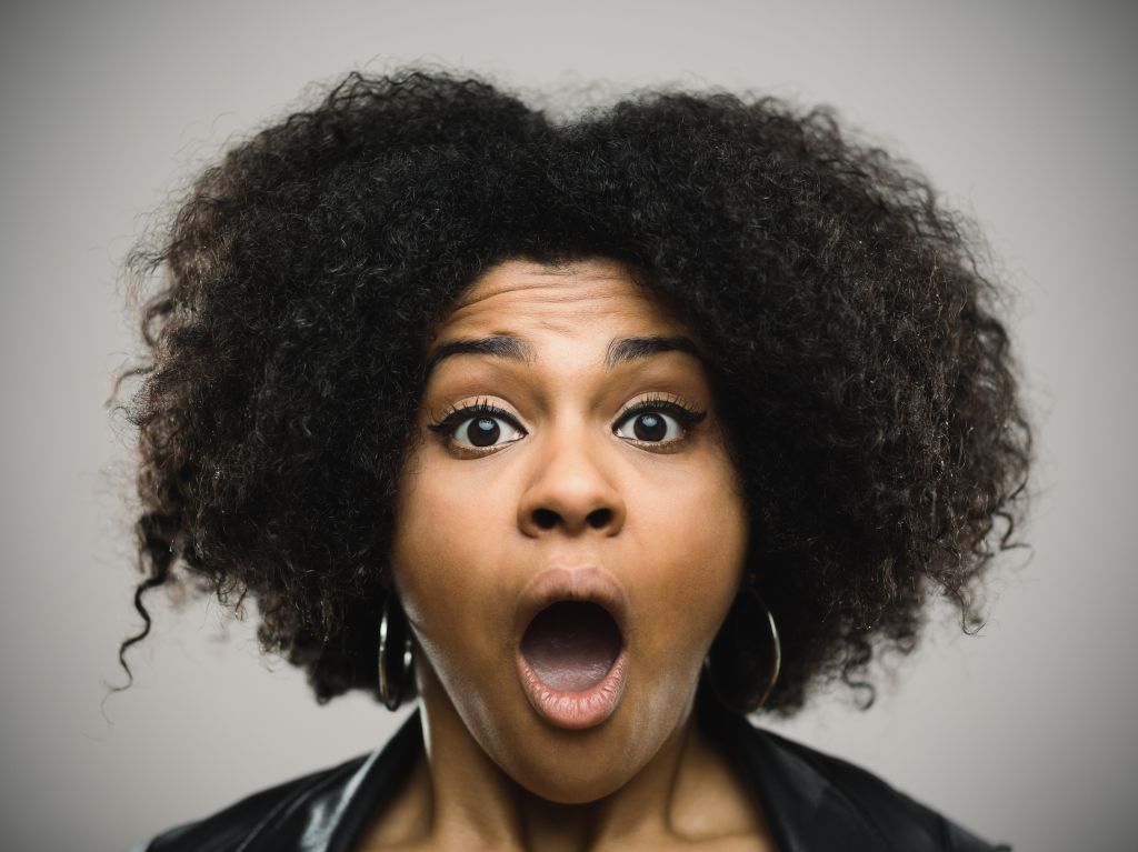 Close-up portrait of a shocked real young afro american woman