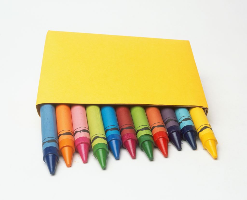 Tips of coloured crayons emerging from a yellow box, front view.