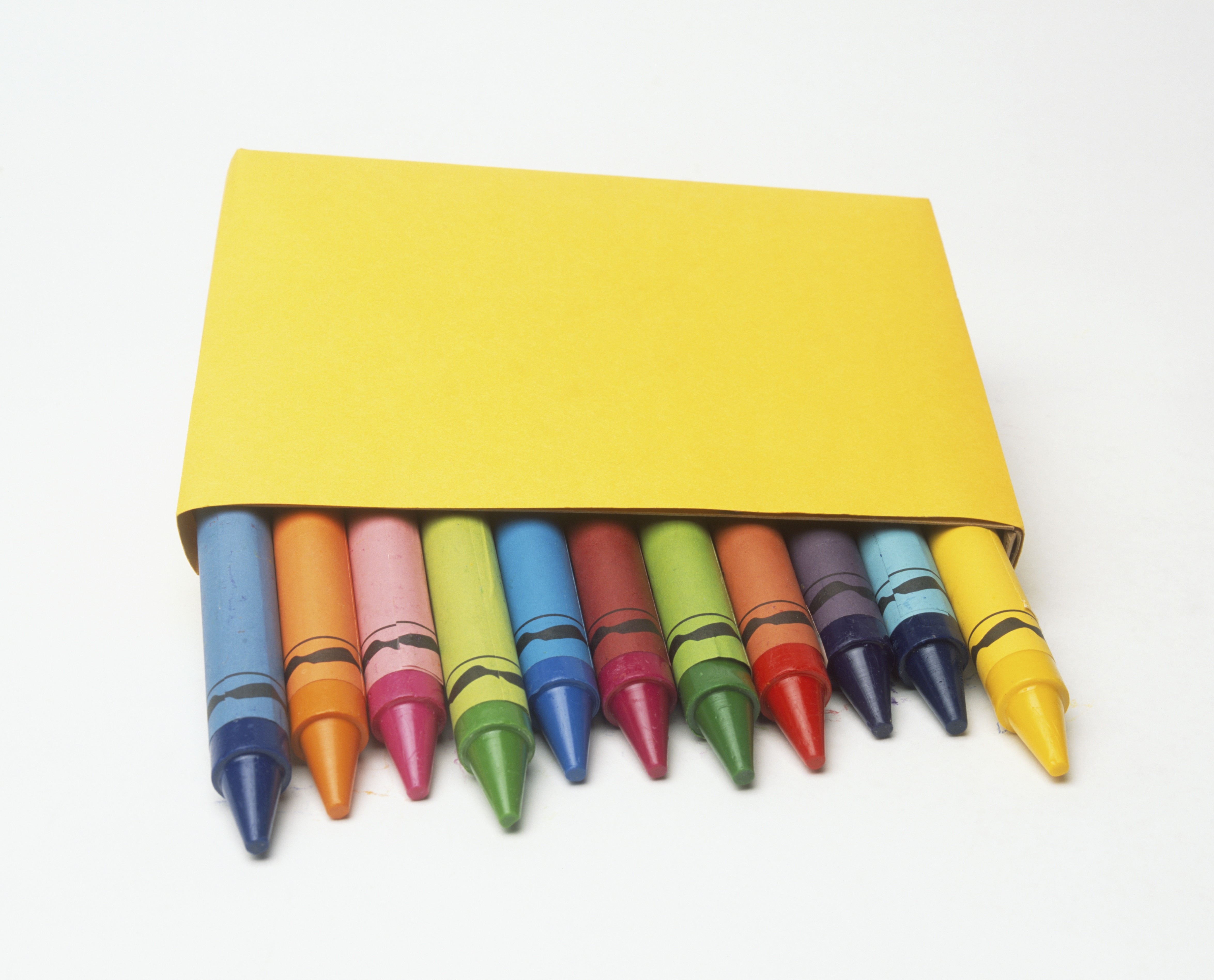 Tips of coloured crayons emerging from a yellow box, front view.