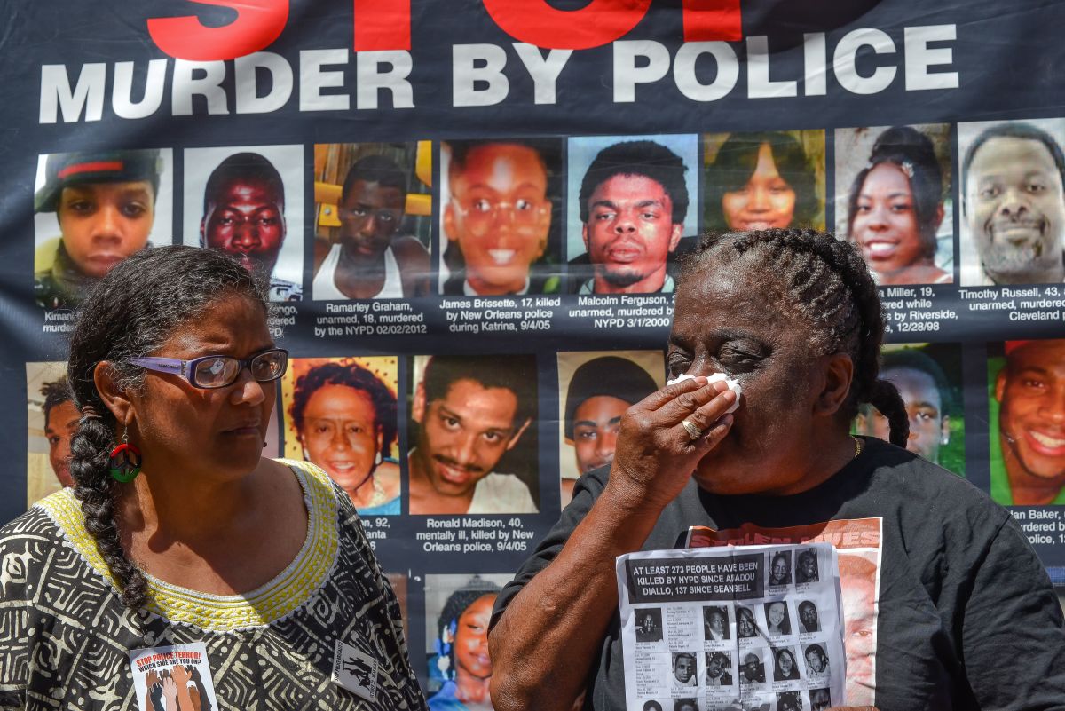 Juanita Young (right) tries a tear from her eye while...