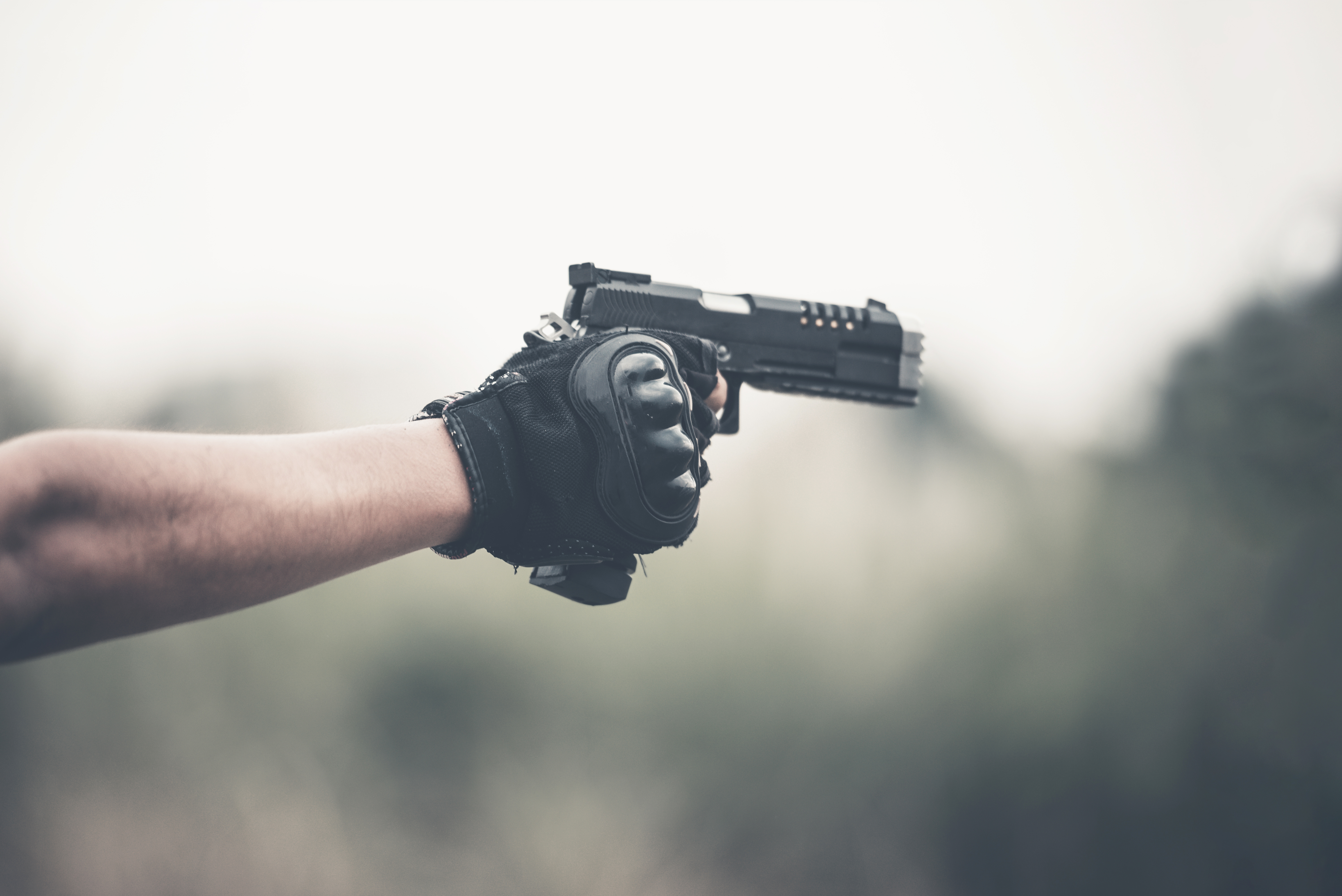 A vintage color photo selective focus man's hand holding a gun. 9 mm pistol.
