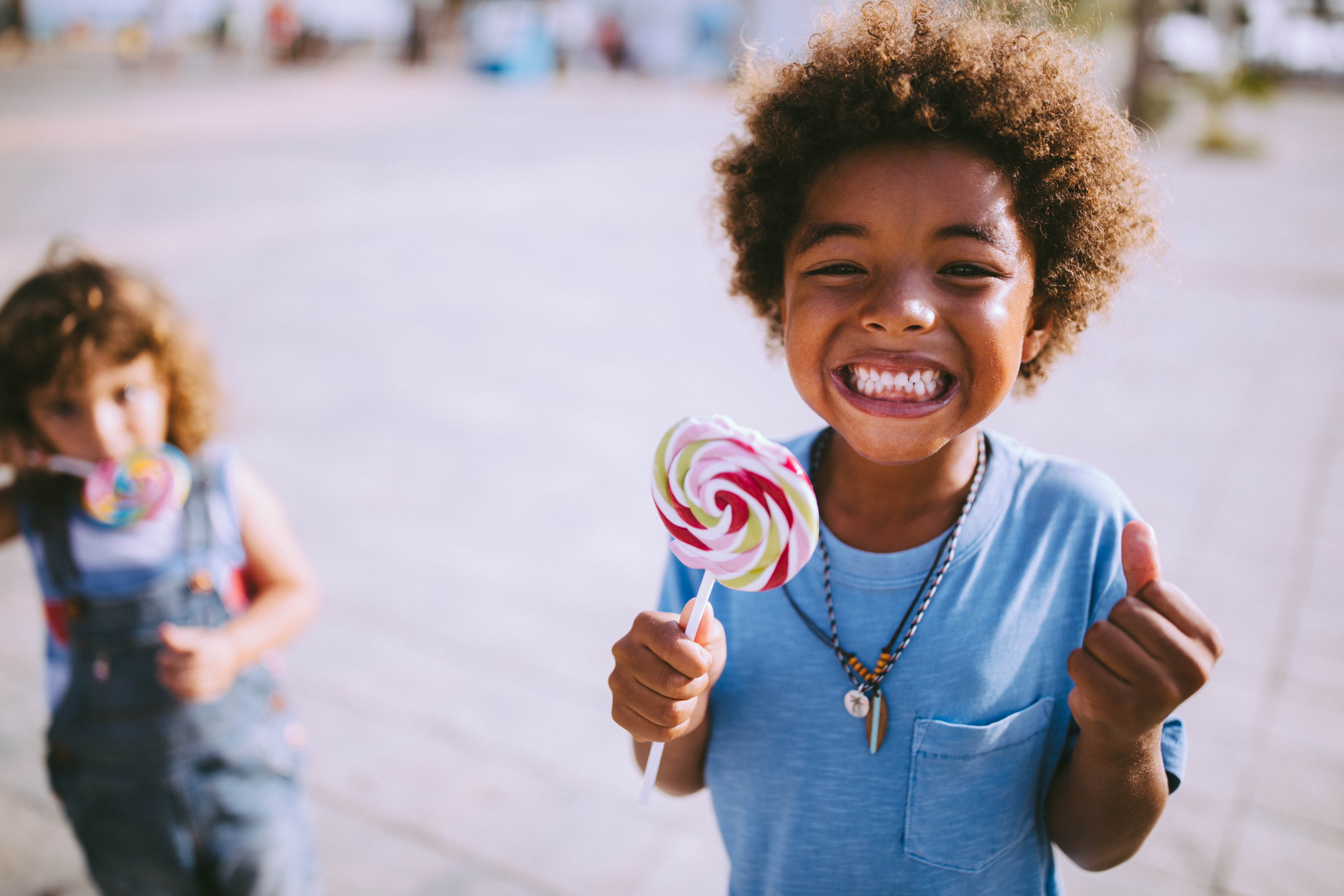 Multi-ethnic children with colorful lollipops outdoors on summer vacations