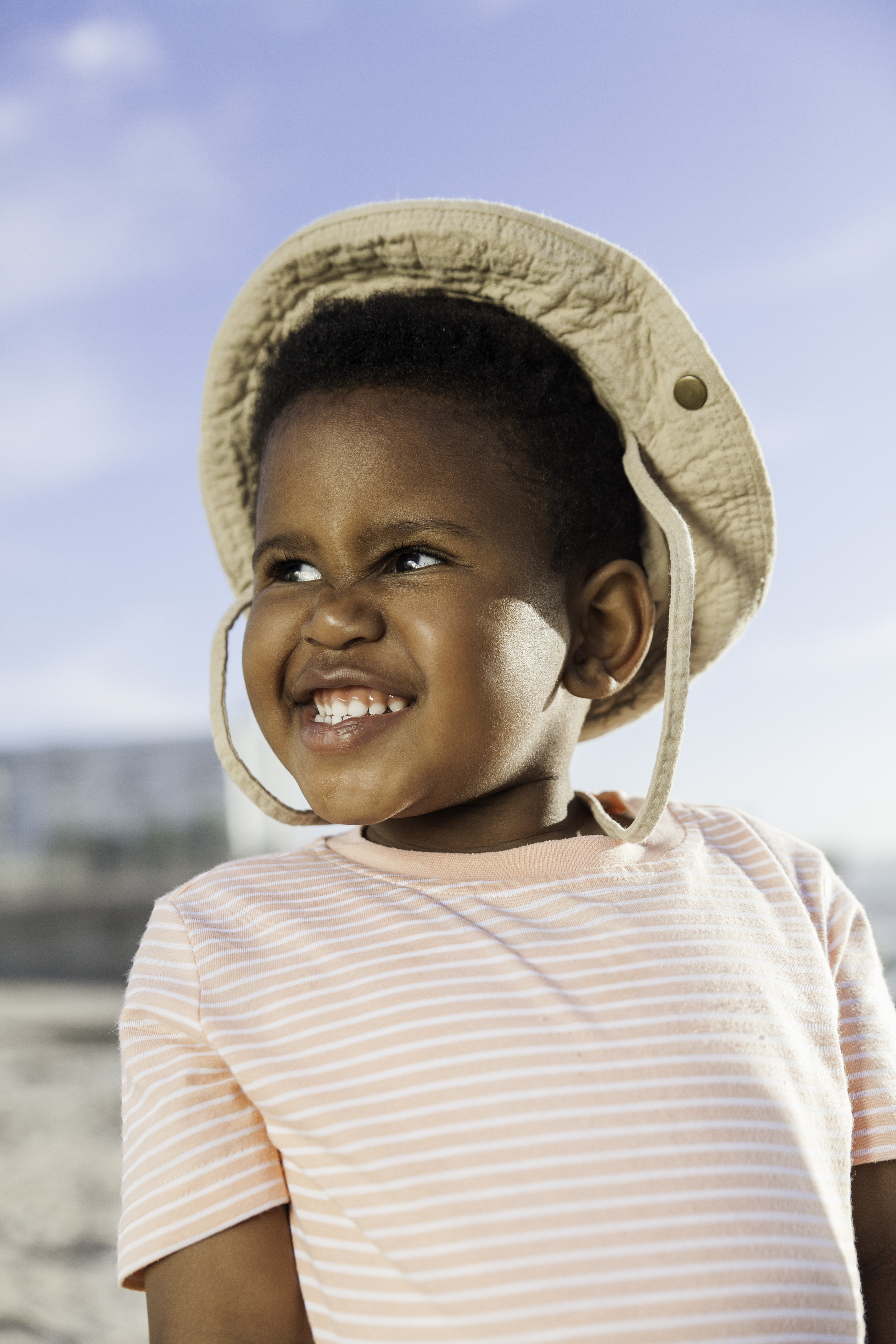 Child smiles widely at the beach.