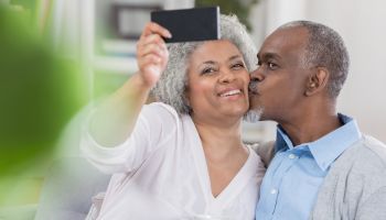 Senior couple pose for selfie at home