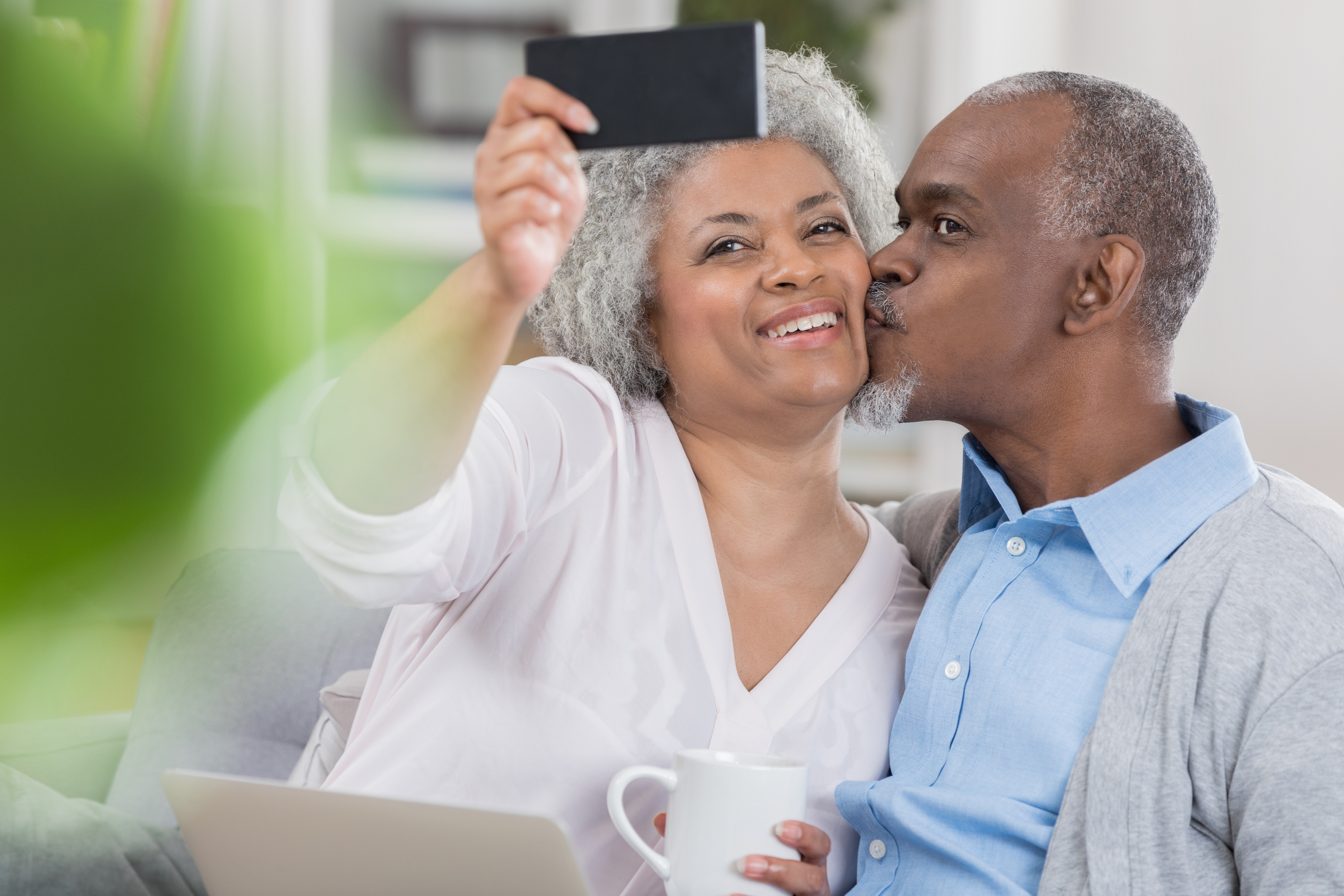 Senior couple pose for selfie at home