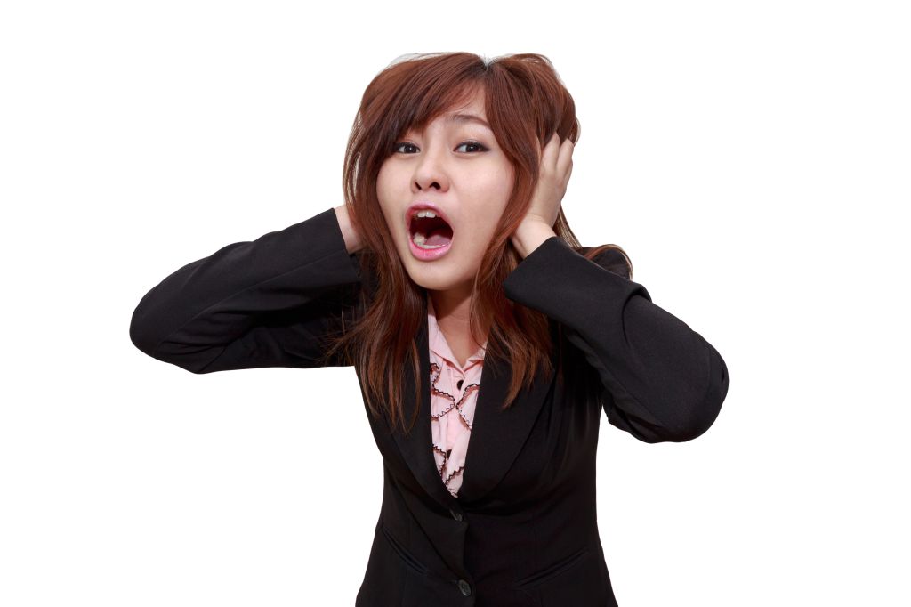 Portrait Of Woman Screaming While Standing Against White Background