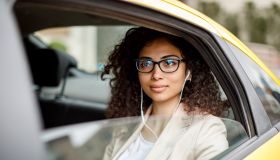 Businesswoman listening to music while commuting to work by taxi