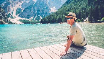 Senior Man Sitting at Lake Braies in the Dolomite Alps, South Tyrol, Italy, Europe
