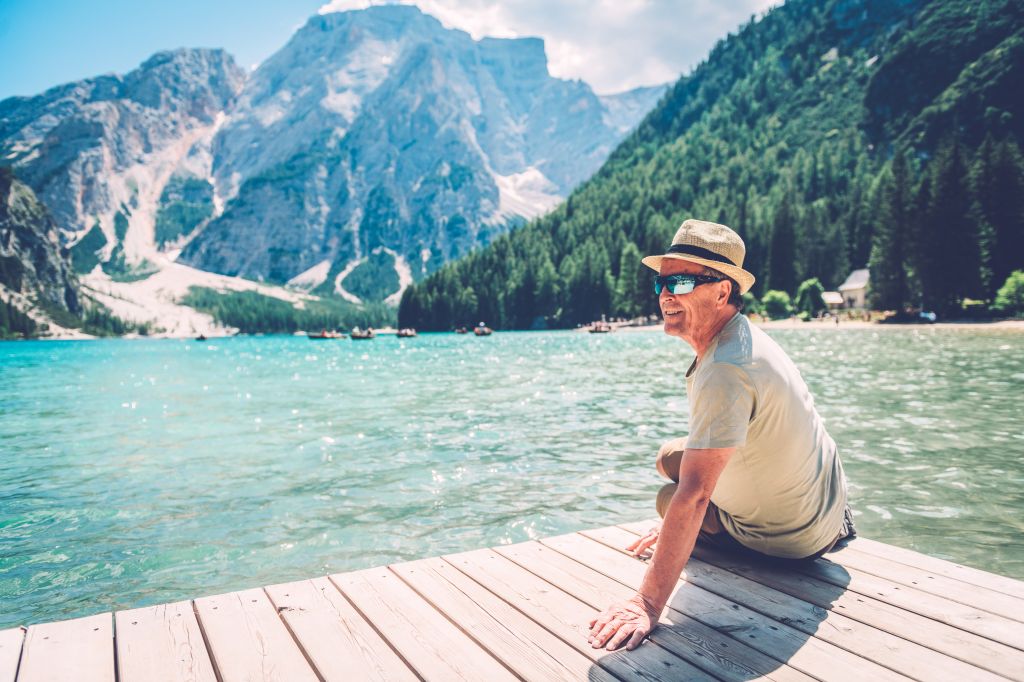 Senior Man Sitting at Lake Braies in the Dolomite Alps, South Tyrol, Italy, Europe