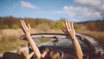 Young women on a road trip with cabriolet