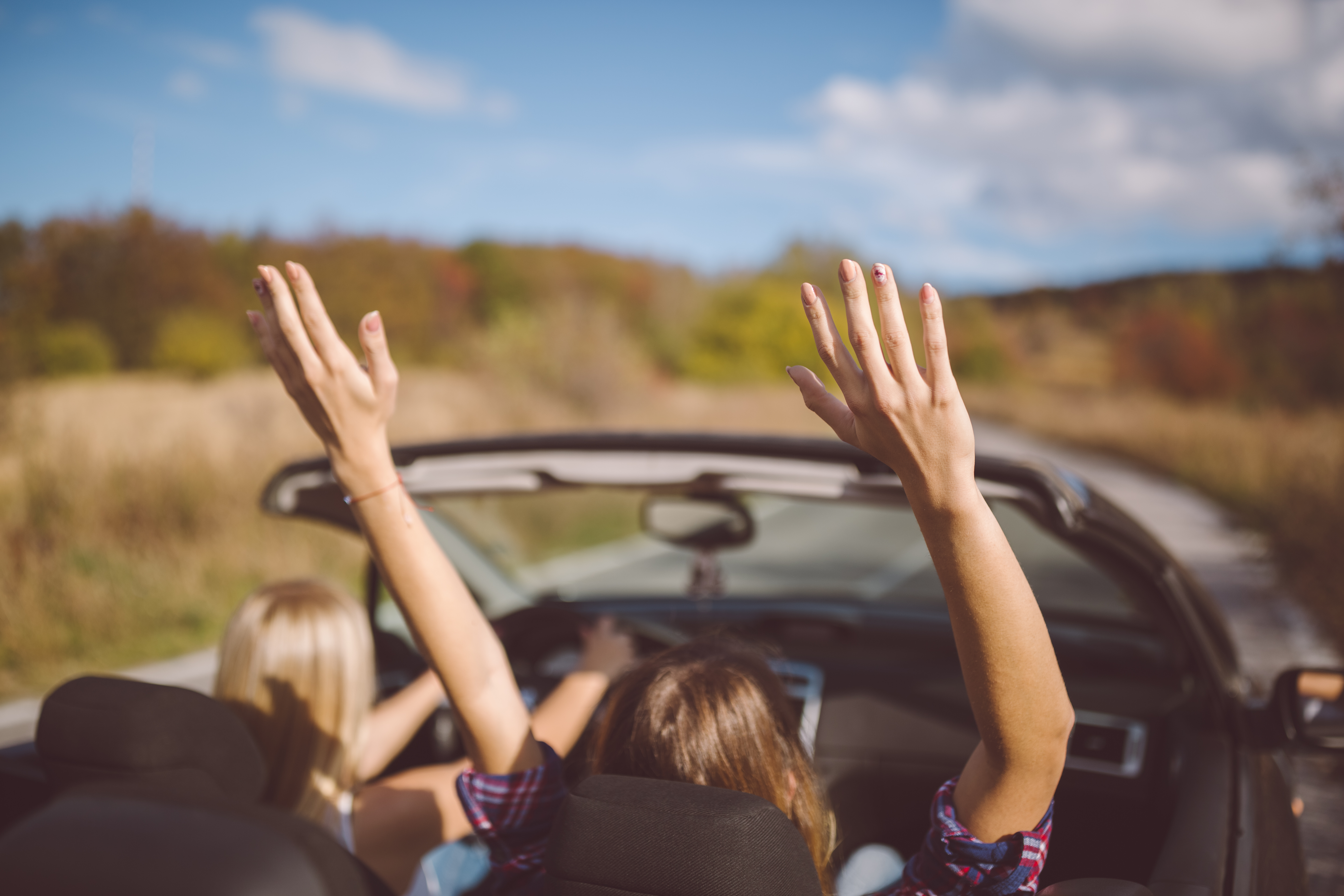 Young women on a road trip with cabriolet