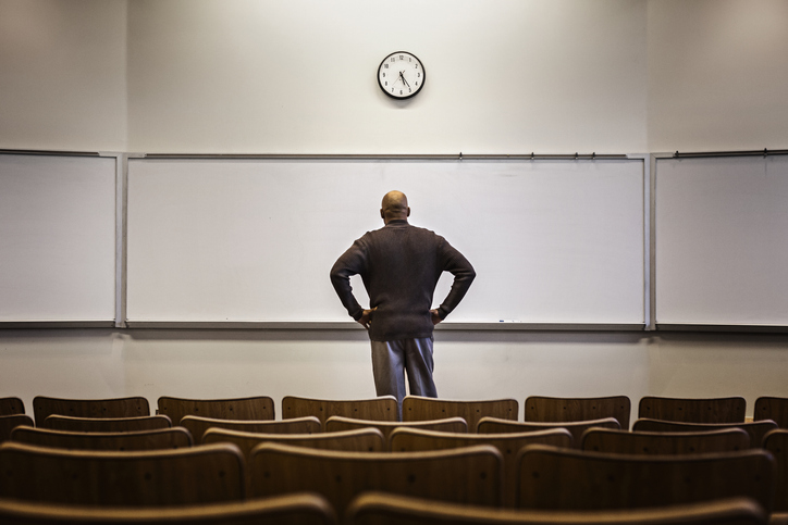 Professor standing in empty classroom