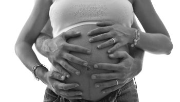 Cropped Hands Of Man Touching Pregnant Belly Against White Background